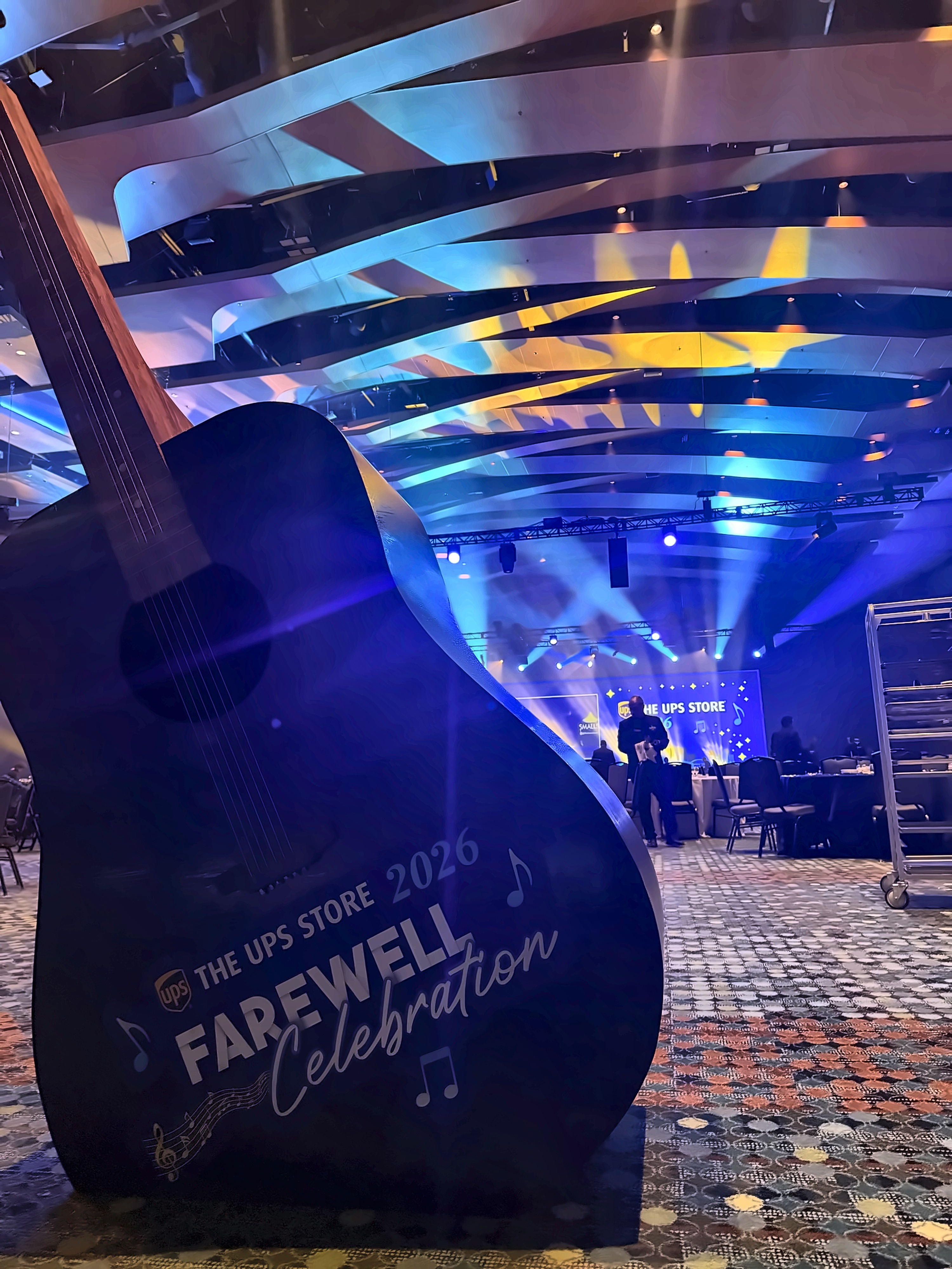 Farewell Celebration branded guitar set piece in the ballroom with the main stage lit up in the background