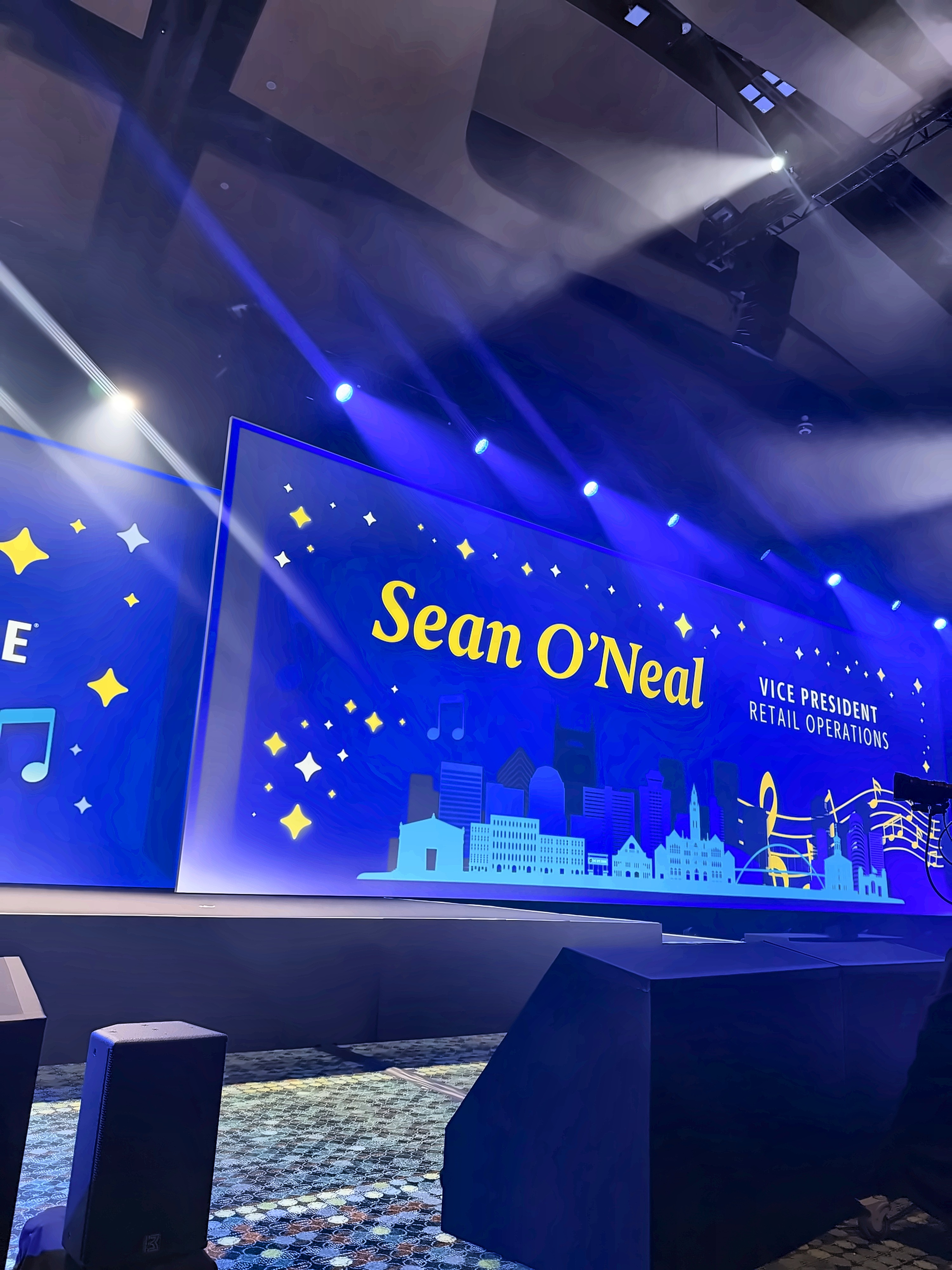 Live photo of the Sean O'Neal title card displayed on the ballroom stage screen